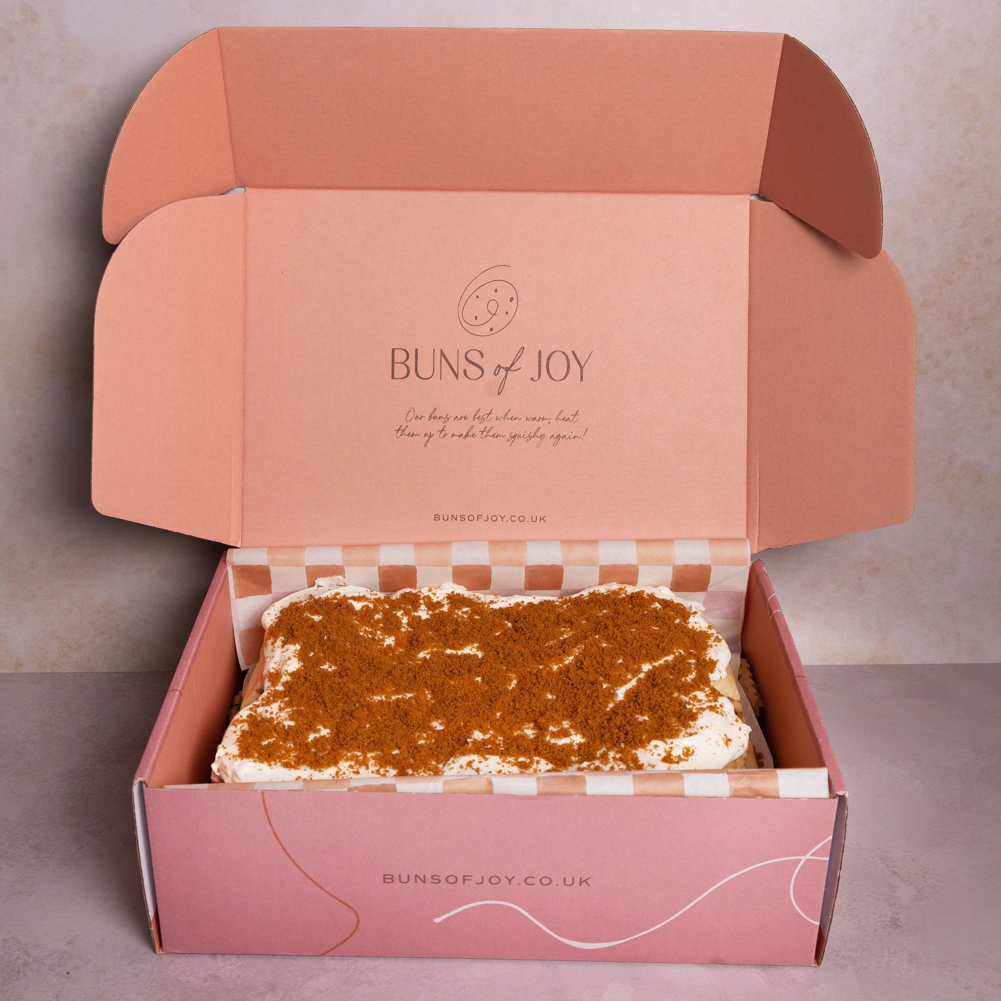 a pink Buns of Joy gift box with The Biscoff Cheesecake buns inside