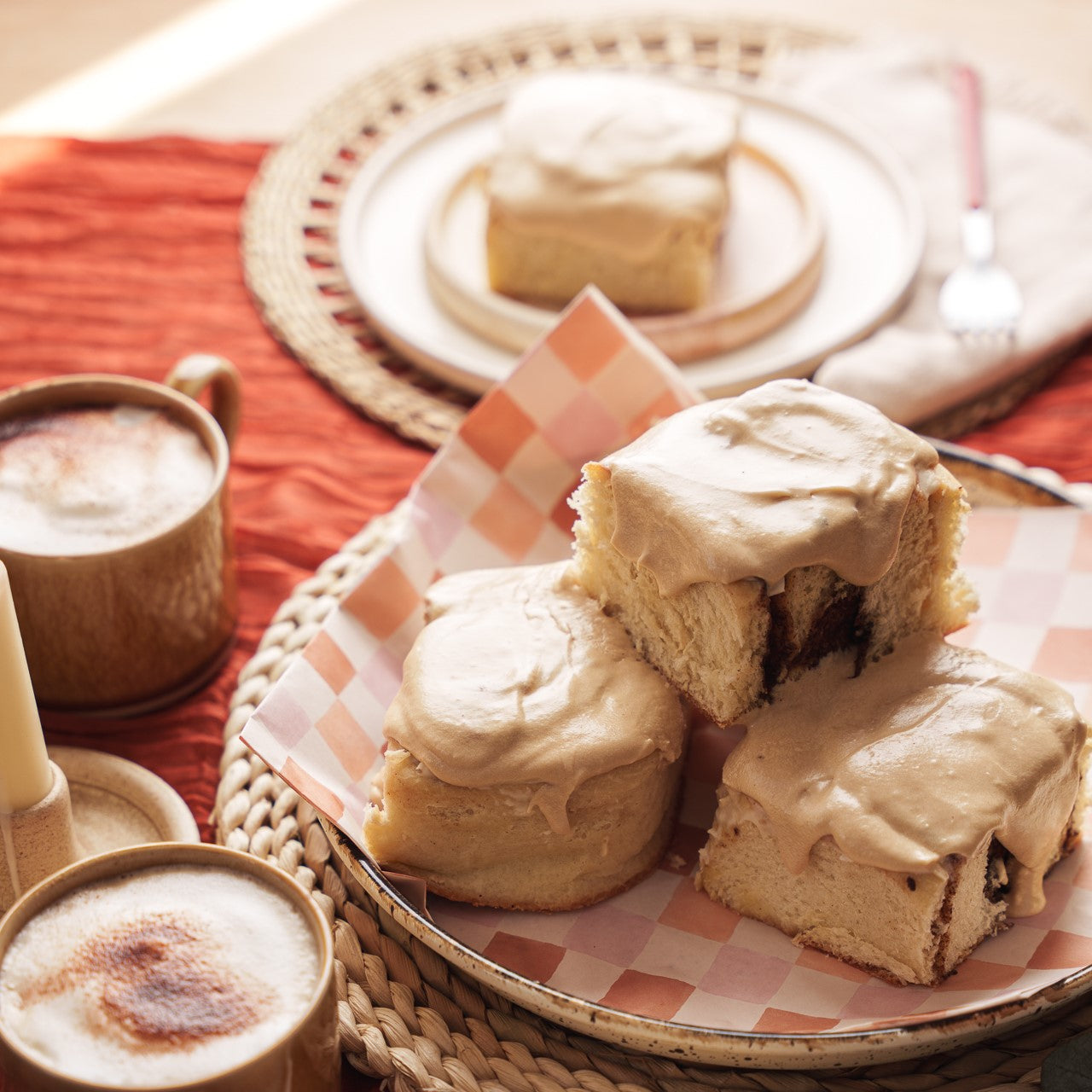 a picture of a plate of spiced latte buns stacked up on a brunch table next to a mug of coffee