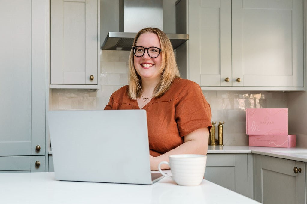 image of Leah smiling and replying to emails on a laptop